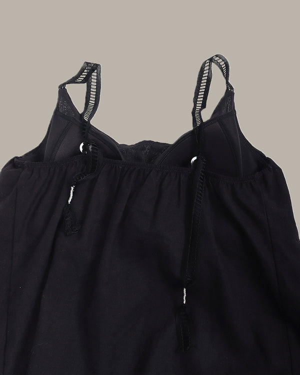 Black top with thin straps on a neutral background