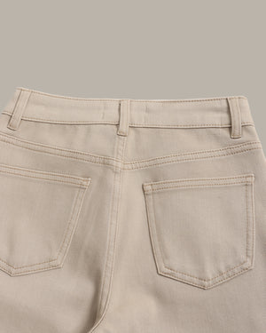 Close-up of the back waistband and rear pockets of light beige denim jeans, showing belt loops, stitching, and pocket details against a solid neutral background.