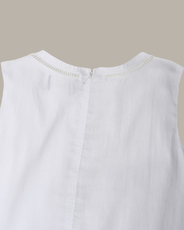 Close-up top part of a white sleeveless dress with a beige background