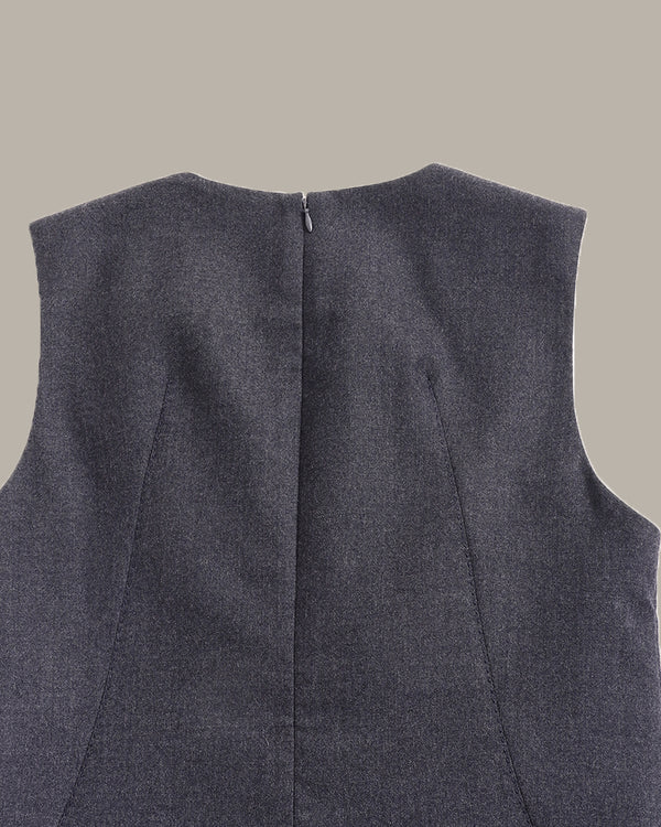 Close-up back view of a sleeveless dark gray textured vest or top, showing a center back zipper and seam details against a solid beige background.