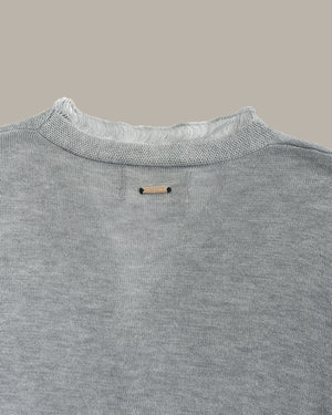 Gray sweater with a brand label on a neutral background