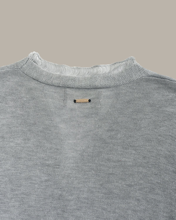 Gray sweater with a brand label on a neutral background