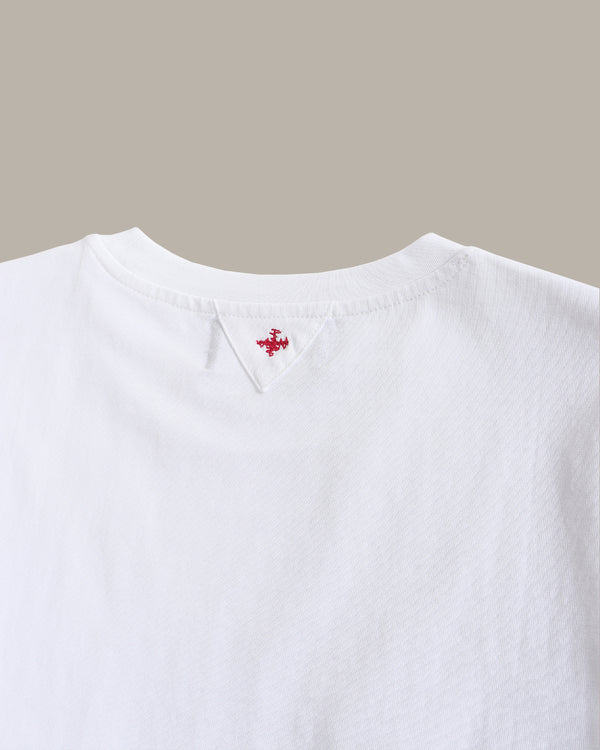 White shirt with a small red logo on a beige background