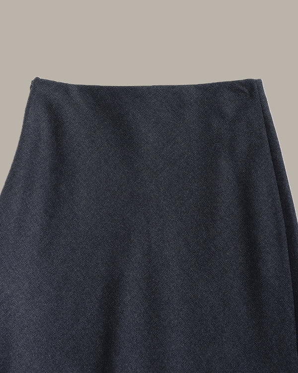 Close-up of a dark navy blue textured fabric, likely a skirt or garment, against a solid light gray background.