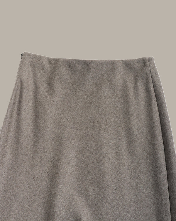 A close-up of a textured gray skirt showing the waistband and drape of the fabric against a solid neutral background.