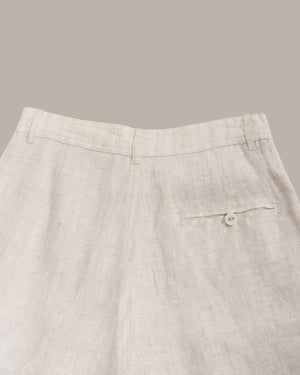 Light gray pants with a button on a beige background