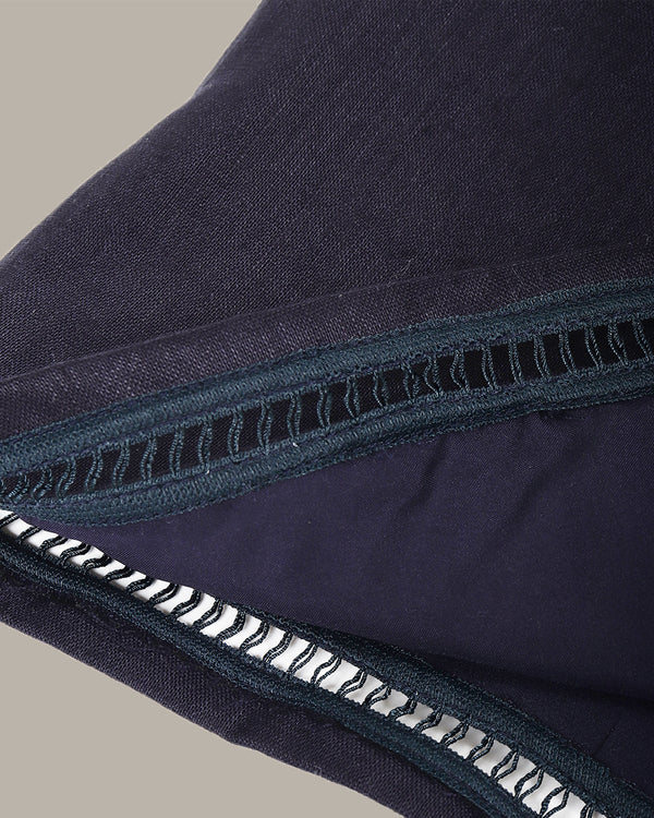 Close-up of navy blue fabric with a zipper on a neutral background