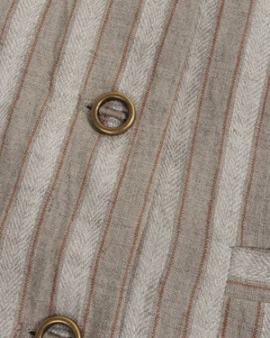 Close-up of a textured fabric with vertical stripes and metal eyelets.