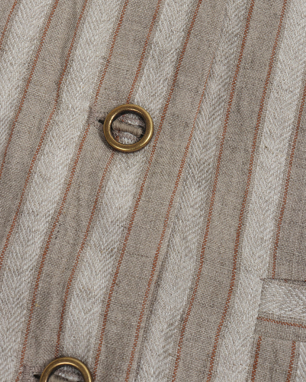 Close-up of a textured fabric with vertical stripes and metal eyelets.