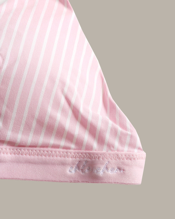 Close-up of a pink garment with thin white vertical stripes and a pink hemband featuring white embroidered script.