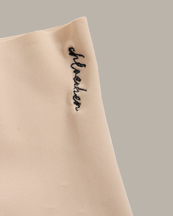 Beige fabric with black embroidered text on a neutral background