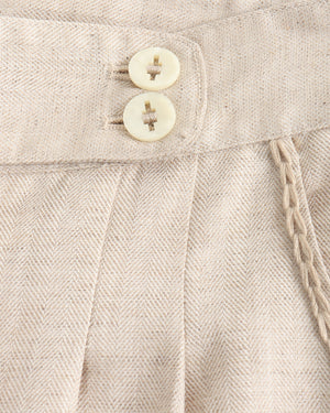 Close-up of beige fabric with buttons and a braided trim