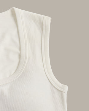 Close-up of a white tank top on a beige background