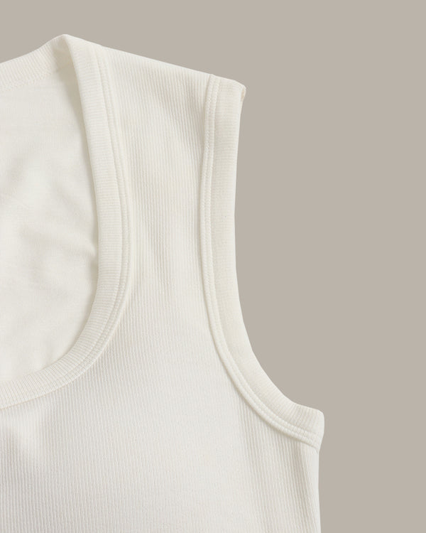 Close-up of a white tank top on a beige background