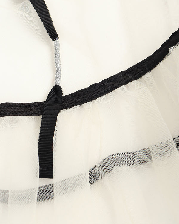 Close-up of a sheer white fabric with black elastic band and silver metal rod.