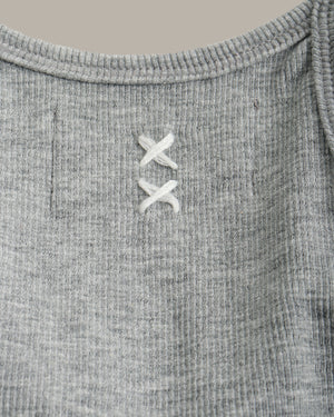 Close-up of a gray textured fabric with a white logo on a beige background