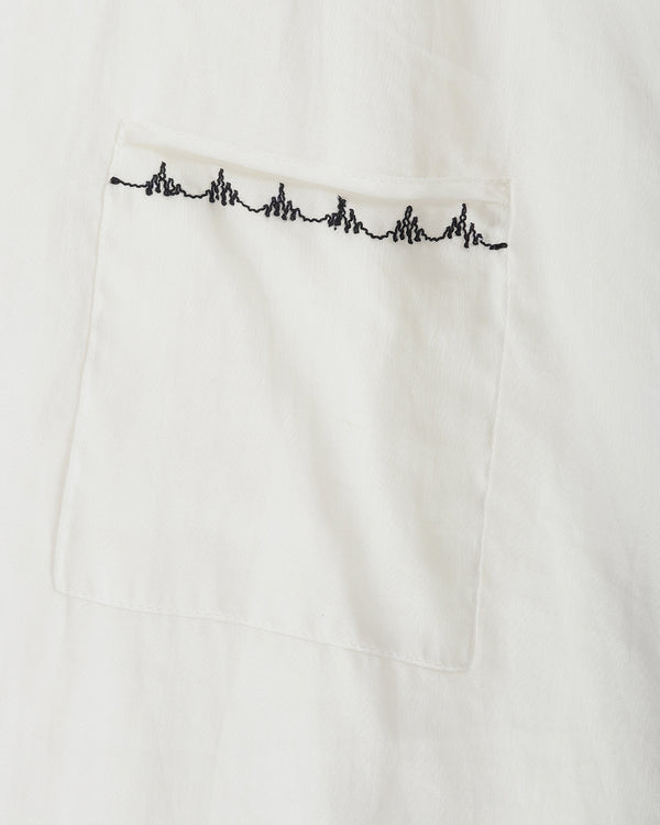 Close-up of a white fabric pocket with a black heartbeat line embroidered across the top edge.