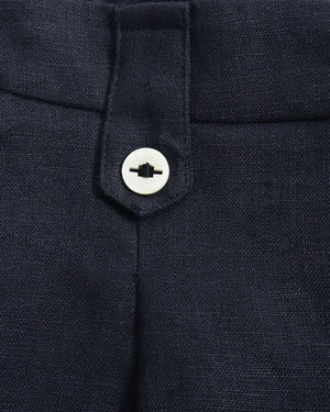 Close-up of dark navy trousers showing the waistband, belt loop, and a white button closure.