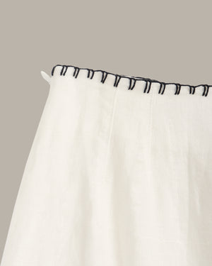 White curtain with black trim on a neutral background
