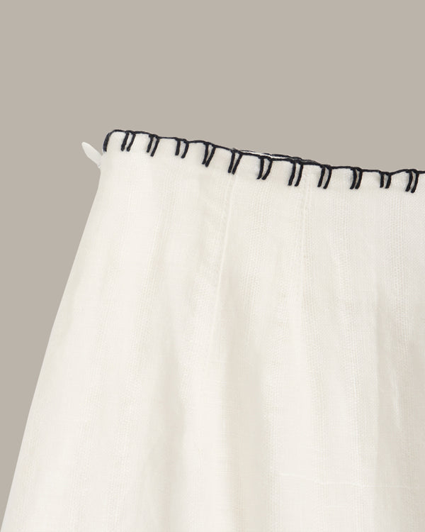 White curtain with black trim on a neutral background