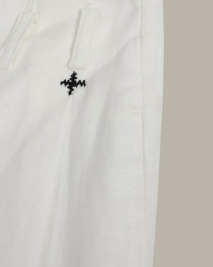 White fabric with a black embroidered design on a beige background