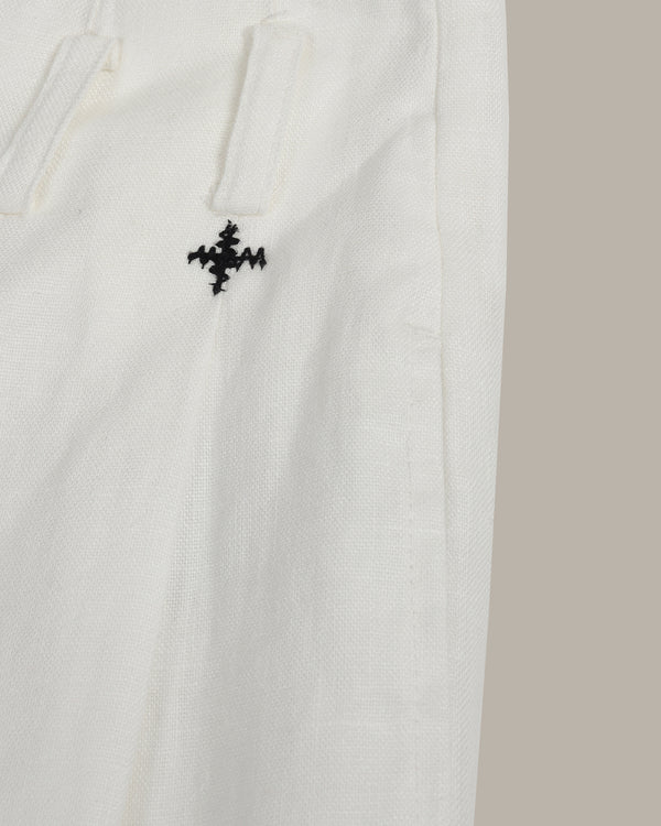 White fabric with a black embroidered design on a beige background