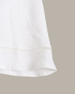 Close-up of a white skirt with a beige background