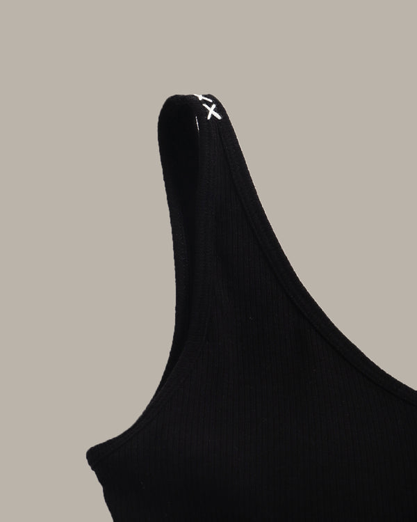 Black sleeveless top with a brand logo on a beige background