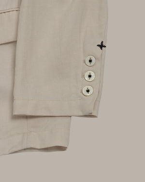 Close-up of blazer sleeves with cross stitching details on a light gray background