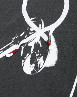 Close-up of a dark gray shirt with white key pattern details and red embroidery accents