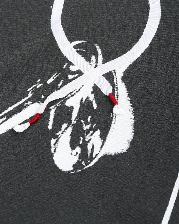 Close-up of a dark gray shirt with white key pattern details and red embroidery accents