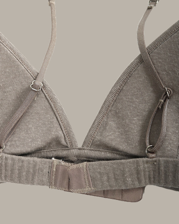 Gray bra on a hanger against a neutral background