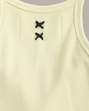 Close-up of a ribbed tank top with black button details on a light green background