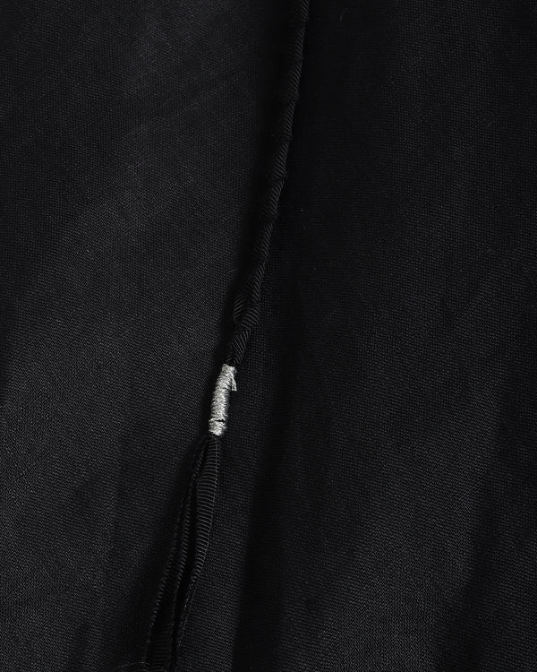 Close-up of a black textured fabric garment with a silver-toned zipper pull.