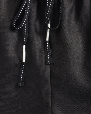 Close-up of a black drawstring on a textured fabric background