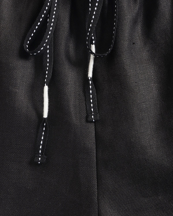 Close-up of a black drawstring on a textured fabric background