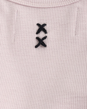 Close-up of a ribbed fabric with black embroidered design on a light pink background