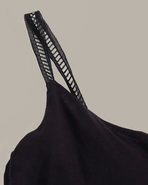 Black top with a textured strap on a beige background