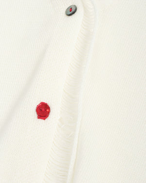 Close-up of a white textured fabric with a red button and gray button on a white background