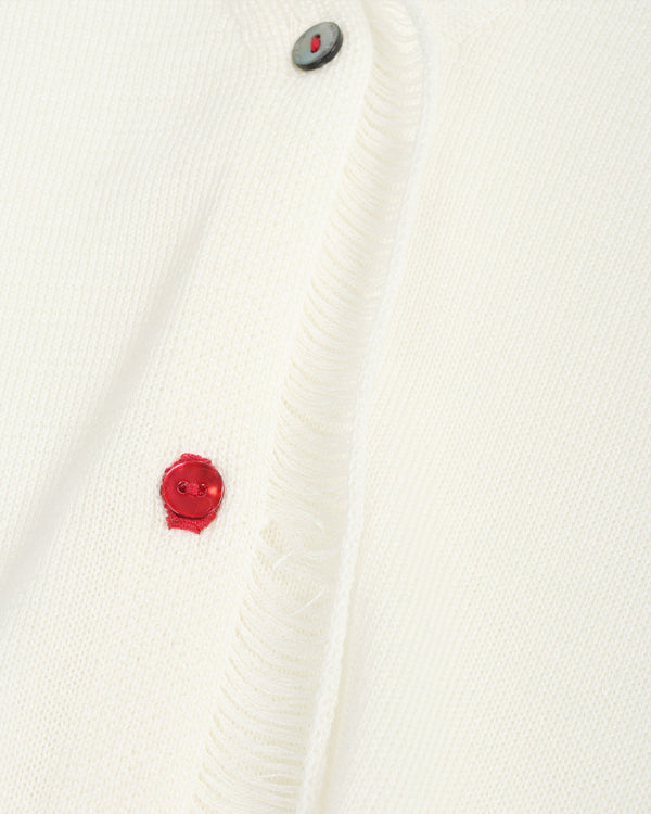 Close-up of a white textured fabric with a red button and gray button on a white background