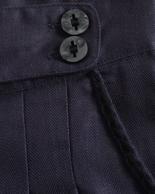 Close-up of a navy blue textured fabric with two buttons.