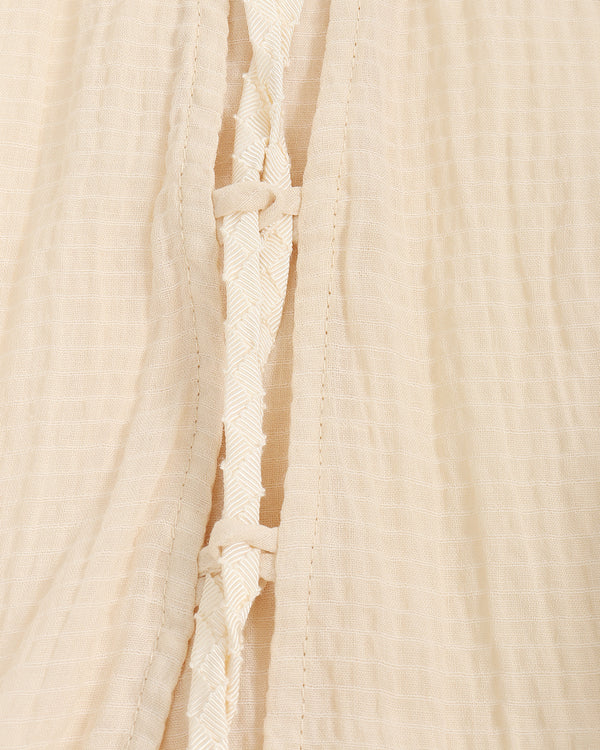 Close-up of beige top with a textured pattern