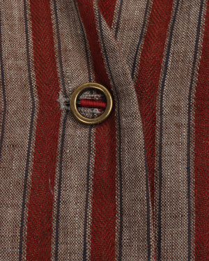 Close-up of a button on a striped fabric with red and brown colors.