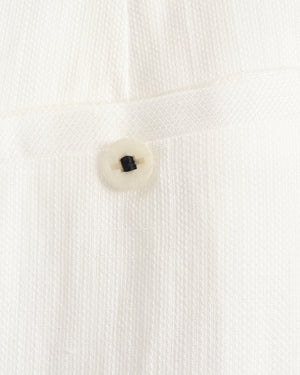 Close-up of a button on a white textured fabric background