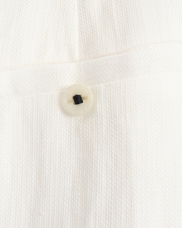 Close-up of a button on a white textured fabric background