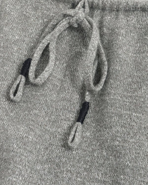 Close-up of a gray heathered knit fabric with matching drawstrings and black ribbed accent tips.