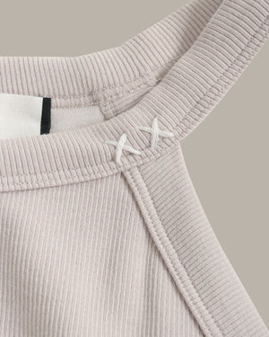 Close-up of a ribbed knit garment with a belt on a neutral background