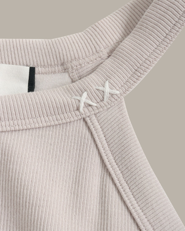 Close-up of a ribbed knit garment with a belt on a neutral background
