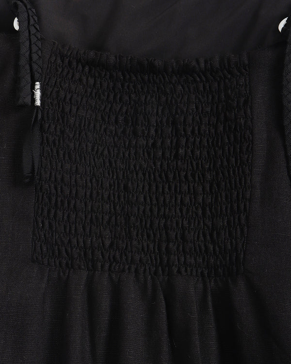 Close-up of a black textured fabric with a patterned square design.