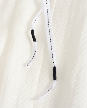 Close-up of a white rope with black ends on a beige background